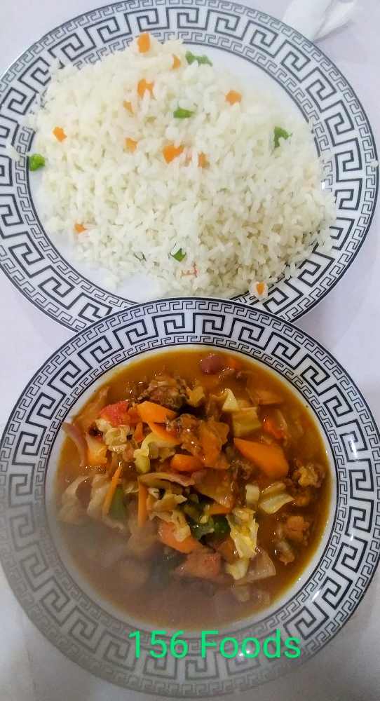 Steamed rice with vegetable and tomatoes chicken sauce.