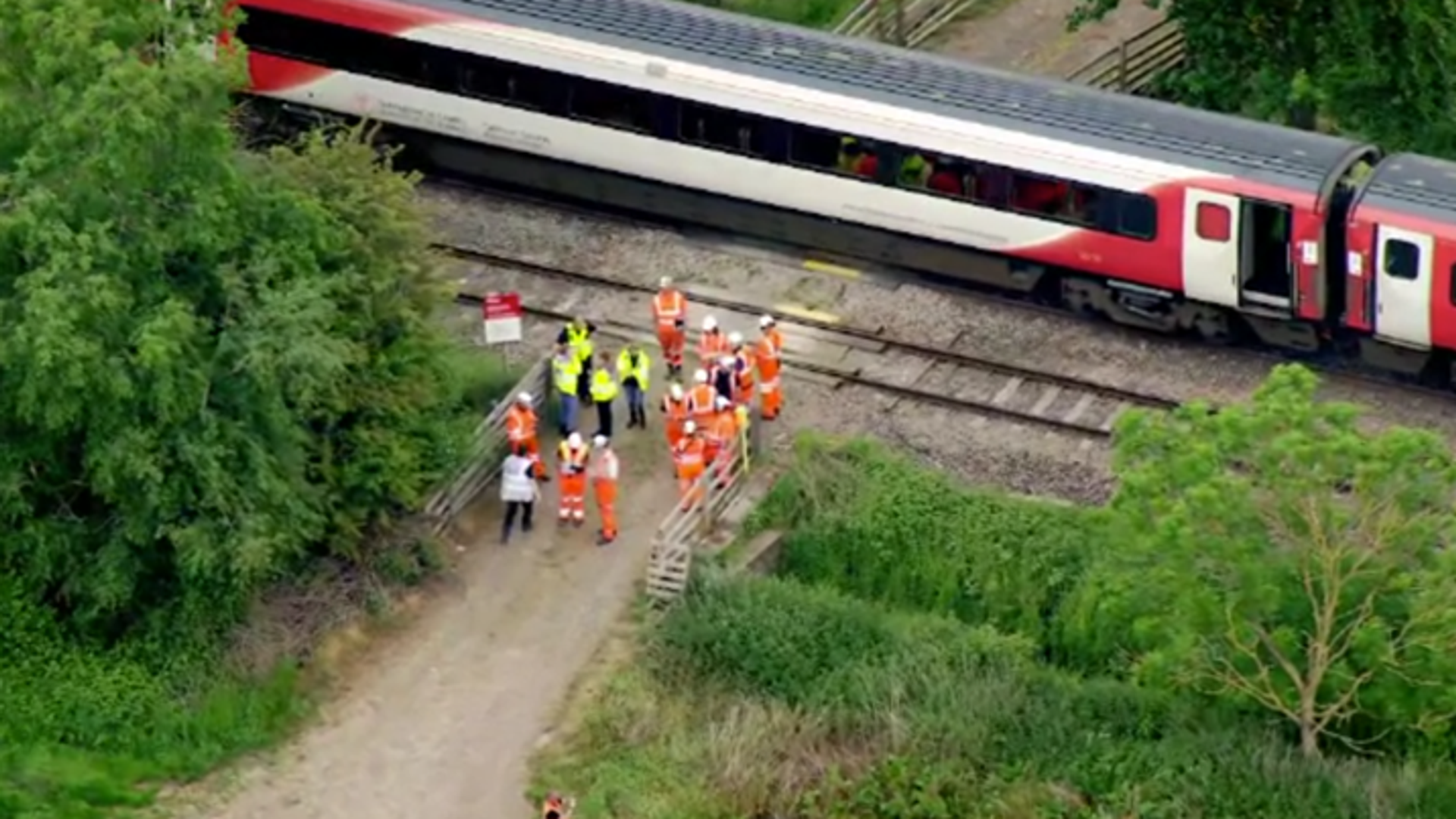 Passengers injured after train hits trailer on level crossing - as police arrest man